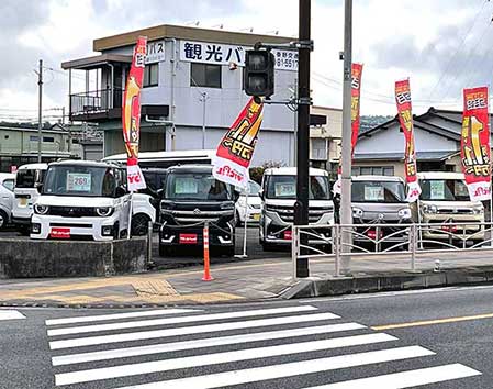 のぼり旗と展示車が並ぶ店舗前